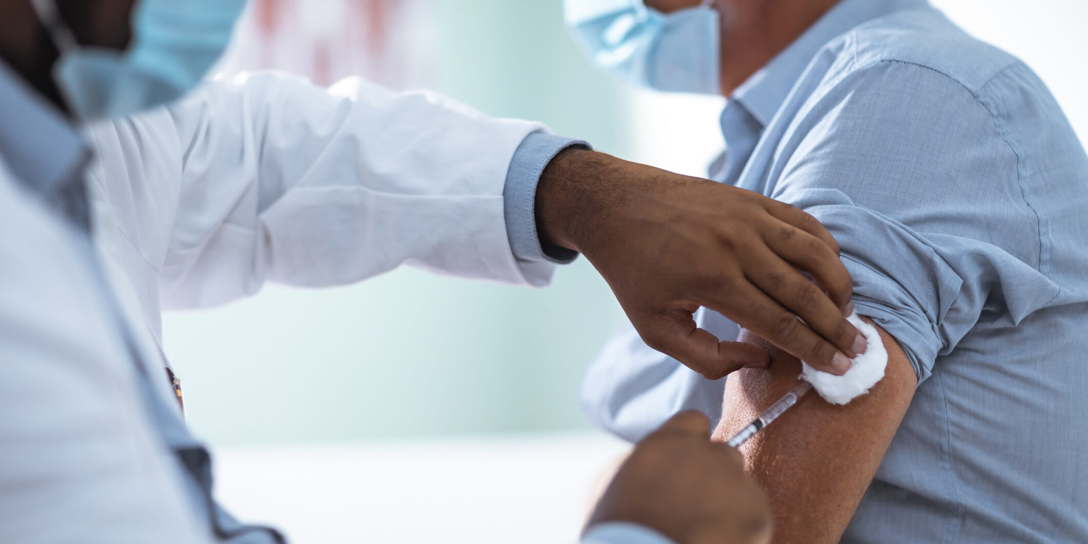 Mature man taking a vaccine from his doctor