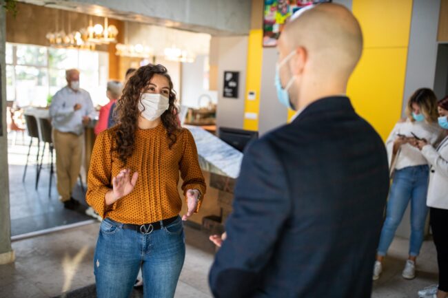 Two business colleagues talking in office building lobby
