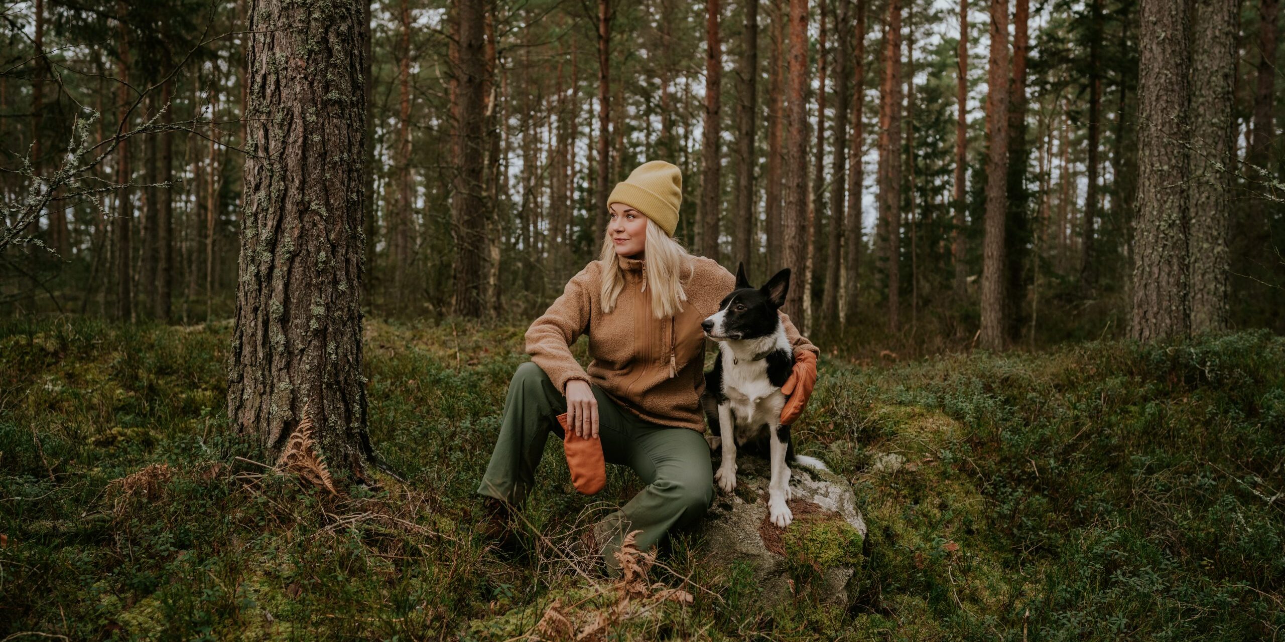 Woman and her dog out on hike in nature forest landscape