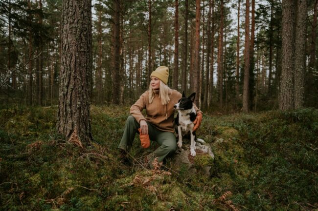 Woman and her dog out on hike in nature forest landscape