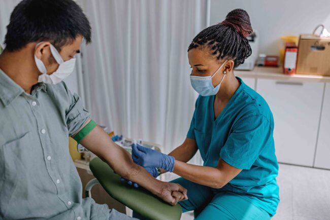 Nurse preparing patient to do a blood analysis Nurse preparing patient to do a blood analysis
