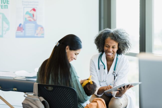 Mom and doctor smile when baby makes noise