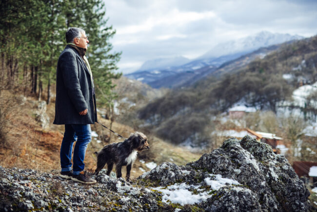 Dog walker enjoys nature with dog Man walking dog in nature.