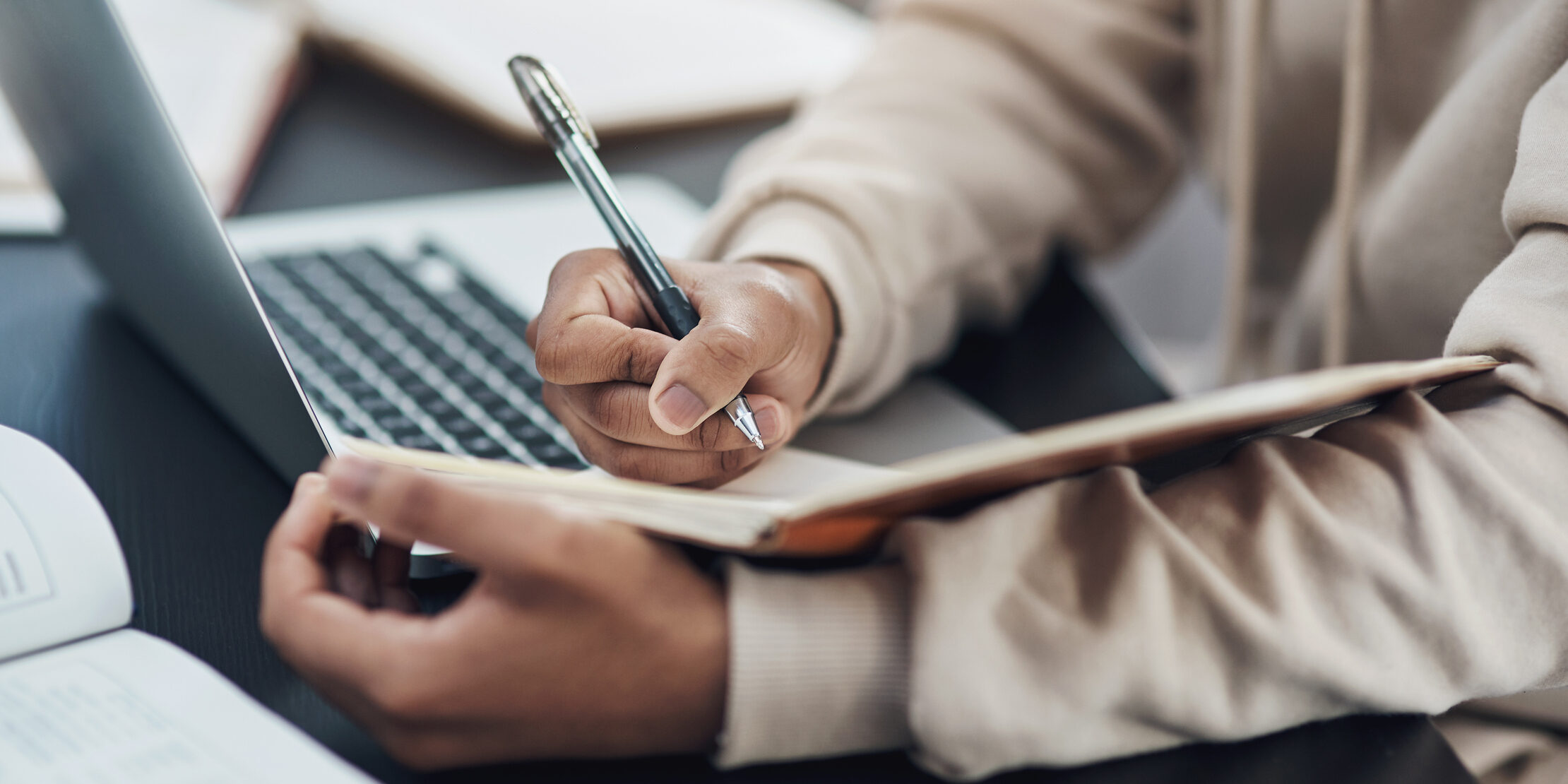 Taking notes on compliance updates. Shot of an unrecognisable man writing in a notebook while working from home
