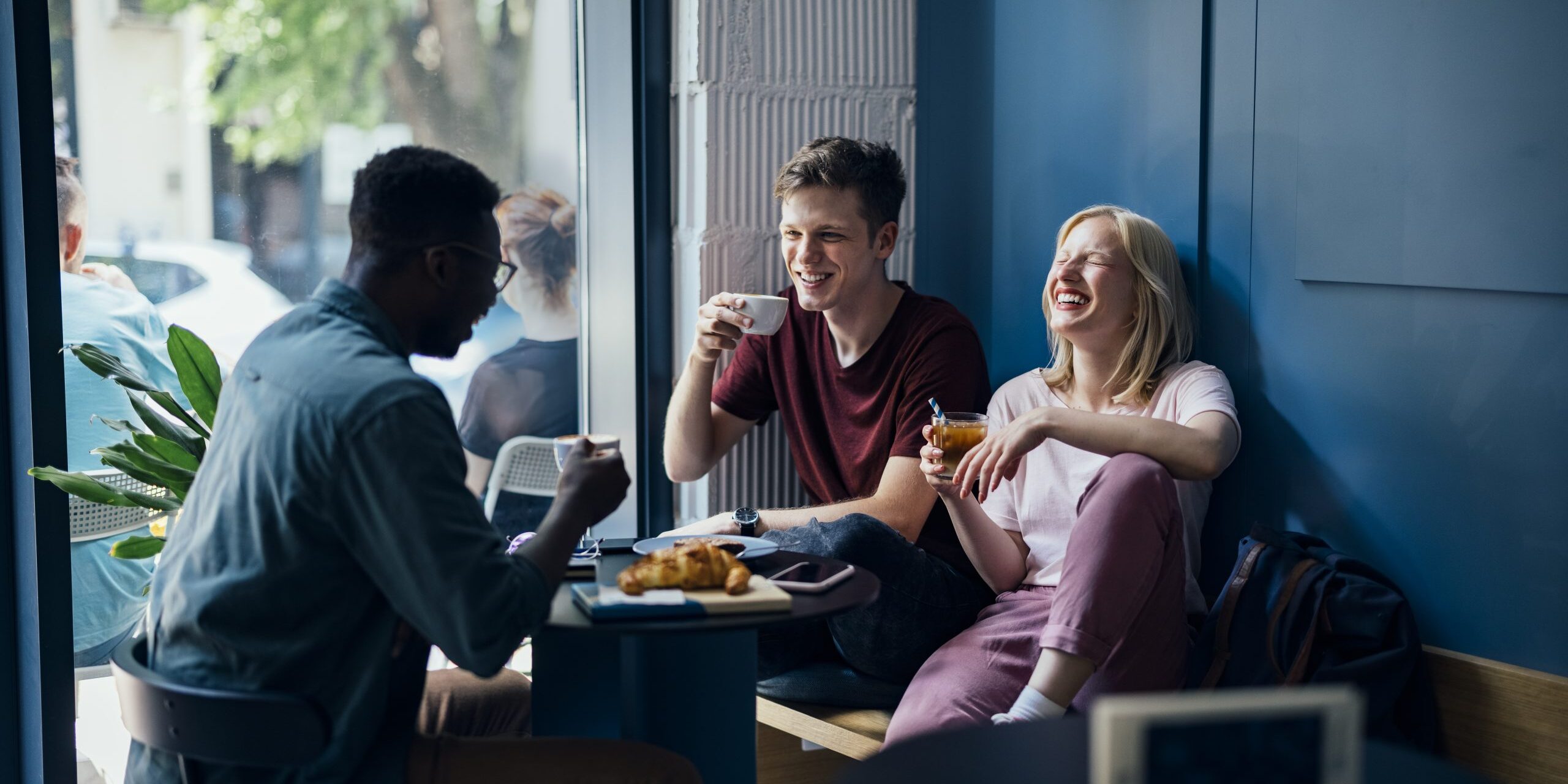 Cheerful Multi Ethnic Group of Friends Having a Breakfast Together in a Cafe