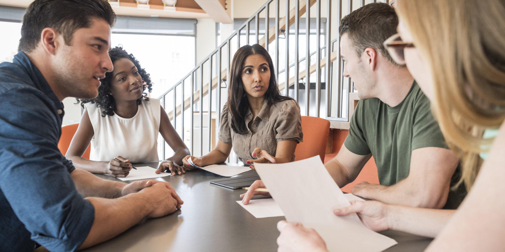 Young woman in meeting listening to colleague with serious expression