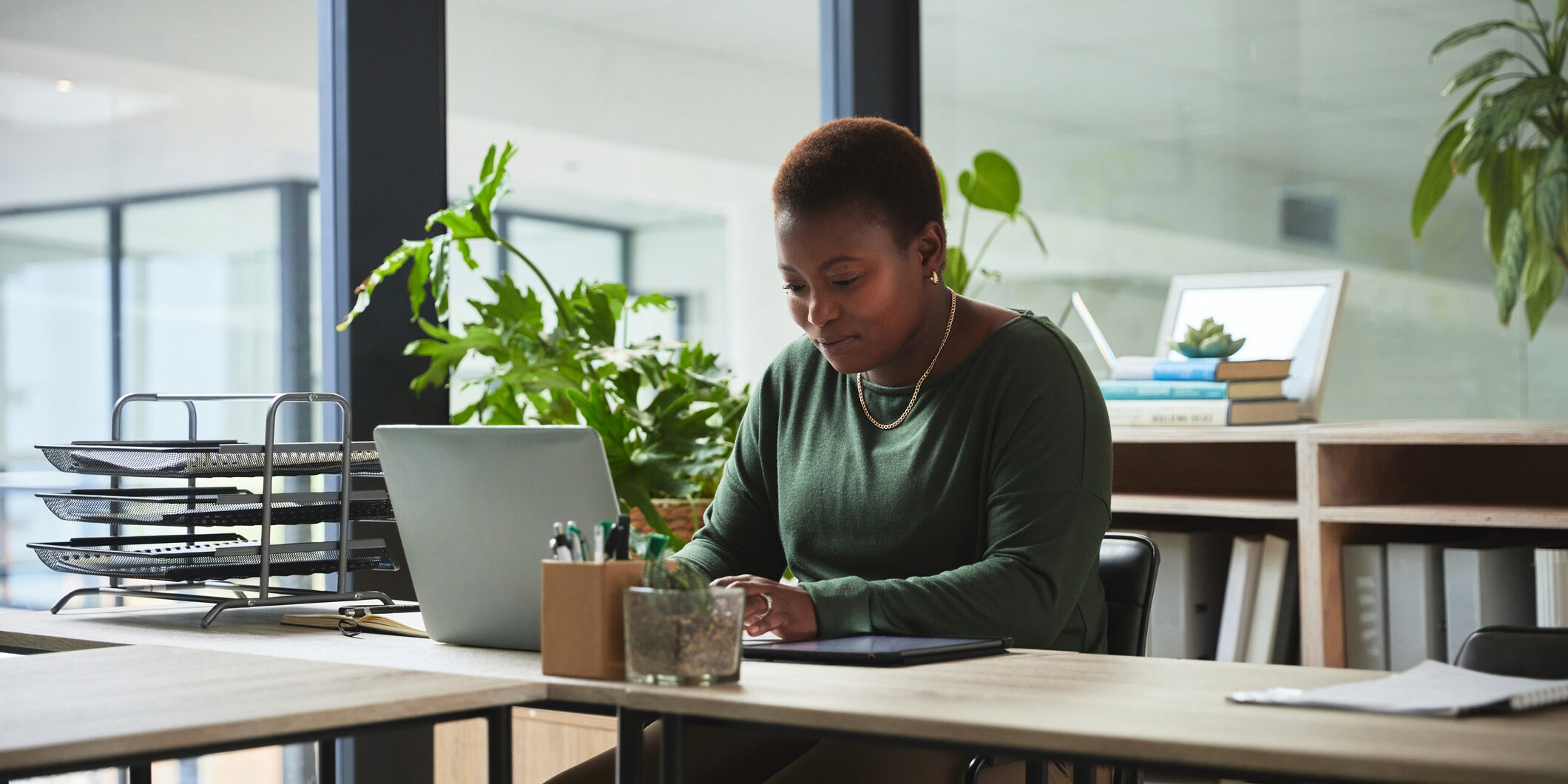 Woman, typing and laptop in a office with digital work at a desk with email at job. African female person, technology and ux designer on a website doing internet research at a company working Woman, typing and laptop in a office with digital work at a desk with email at job. African female person, technology and ux designer on a website doing internet research at a company working