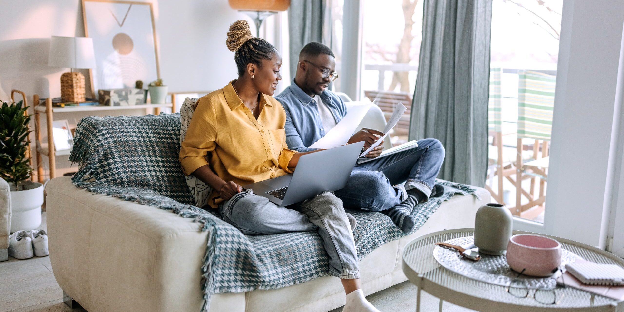 Young smiling couple working from home, going over paperwork