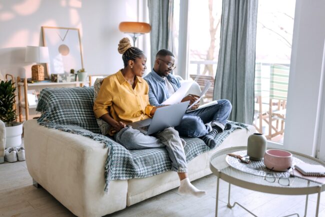 Young smiling couple working from home, going over paperwork