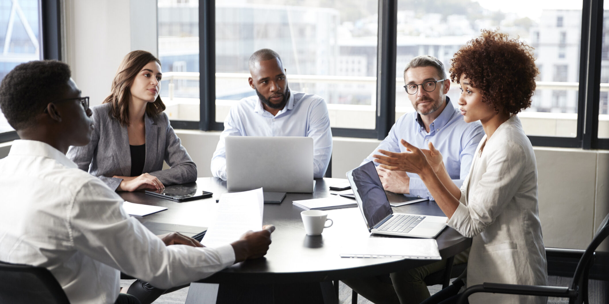 Millennial black businesswoman addressing colleagues at a corporate business meeting, close up