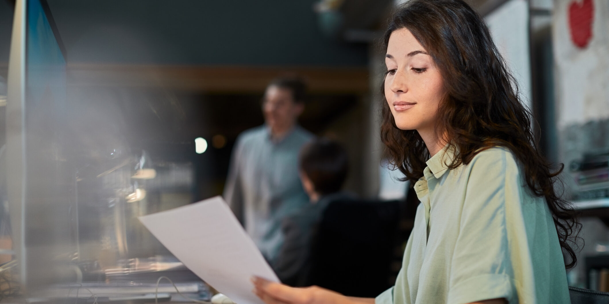 Young businesswoman proofreading paperwork in a small business.