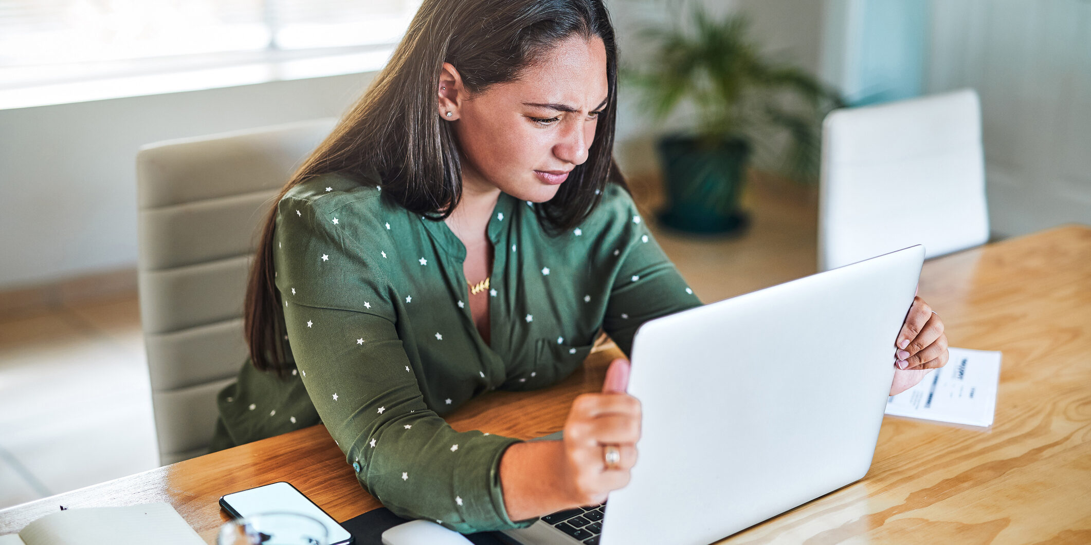 Shot of a young businesswoman gripping her laptop screen in frustration