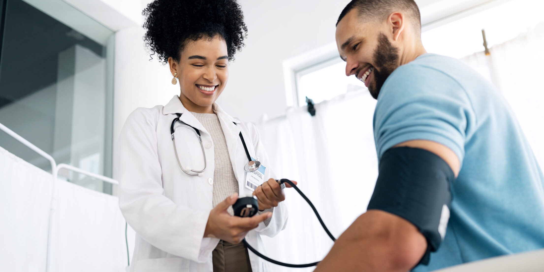 Happy doctor, patient and blood pressure for appointment, checkup or visit at hospital. Medical woman, surgeon or nurse helping man, customer or client for monitoring heart rate at healthcare clinic