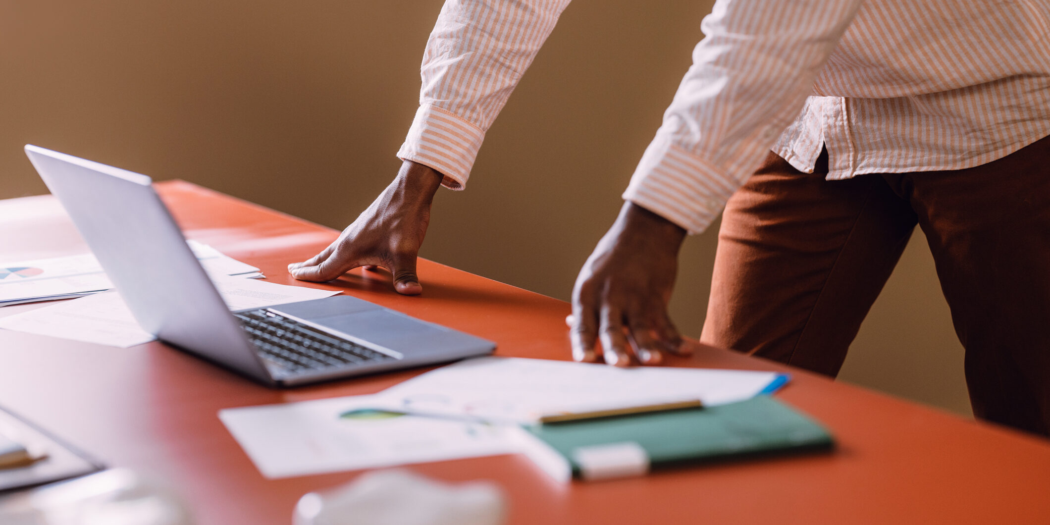 Professional Worker Using Laptop at Business Desk with Documents
