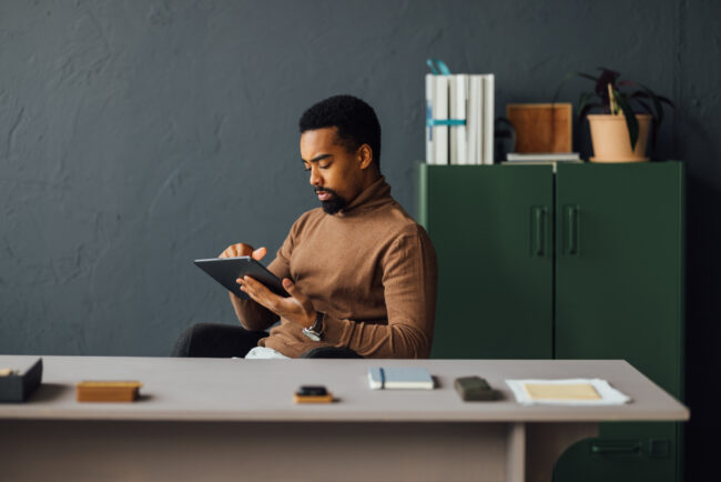 Young Man Working on Tablet in Modern Office Setting