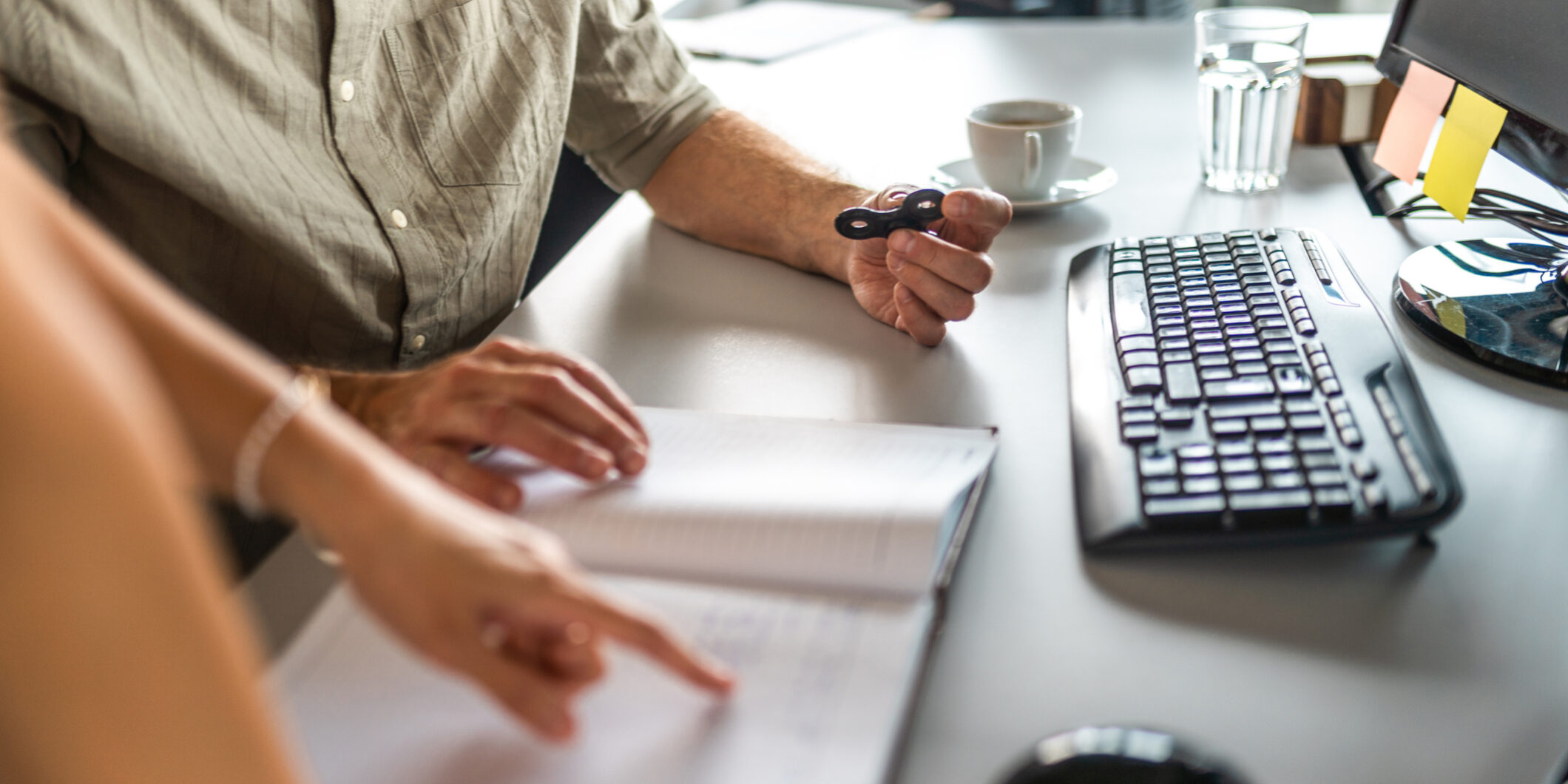 Senior Businessman and Colleague with Stress Relief Toy at Desk