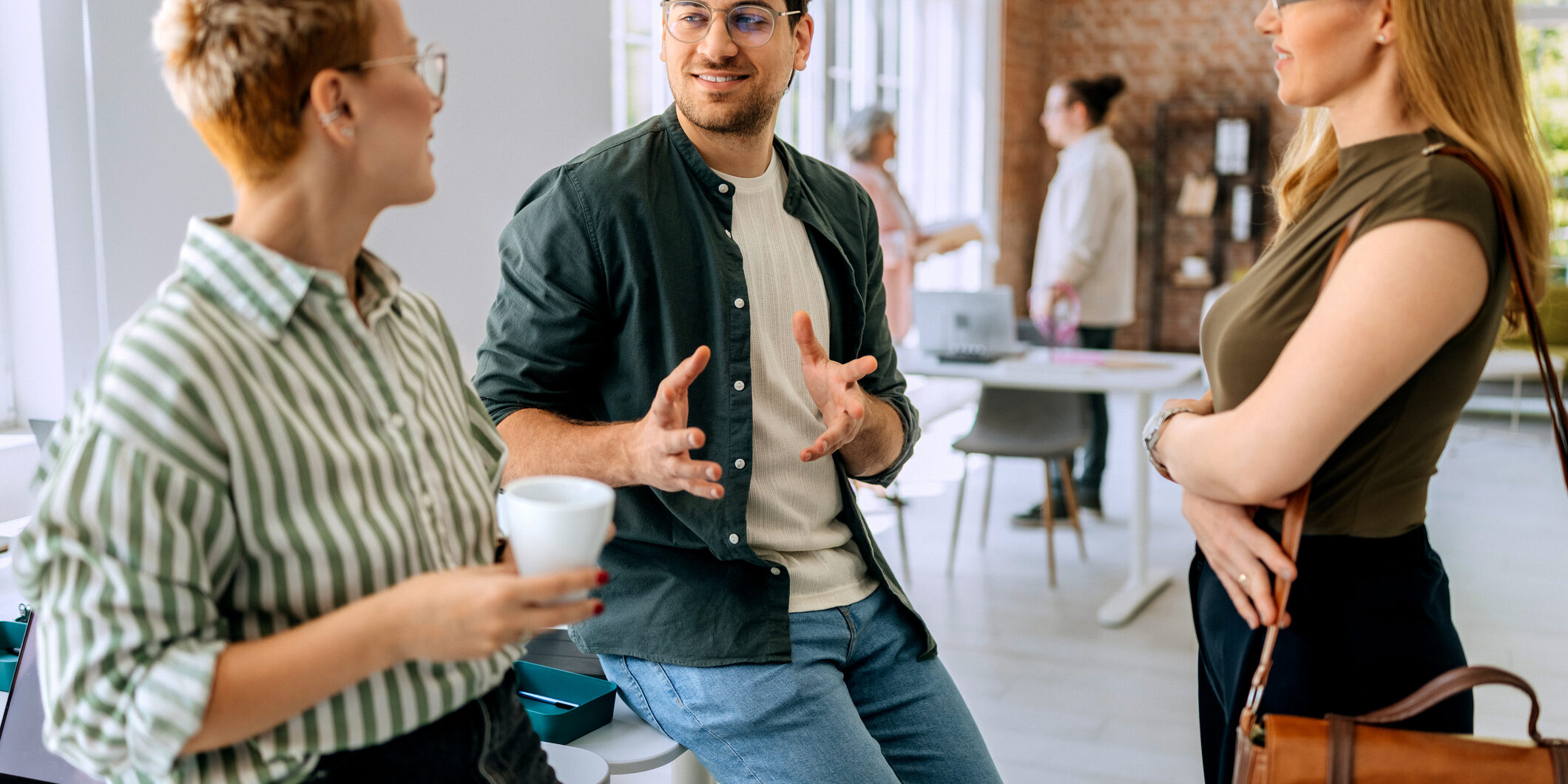 Business team in office having discussion during coffee break
