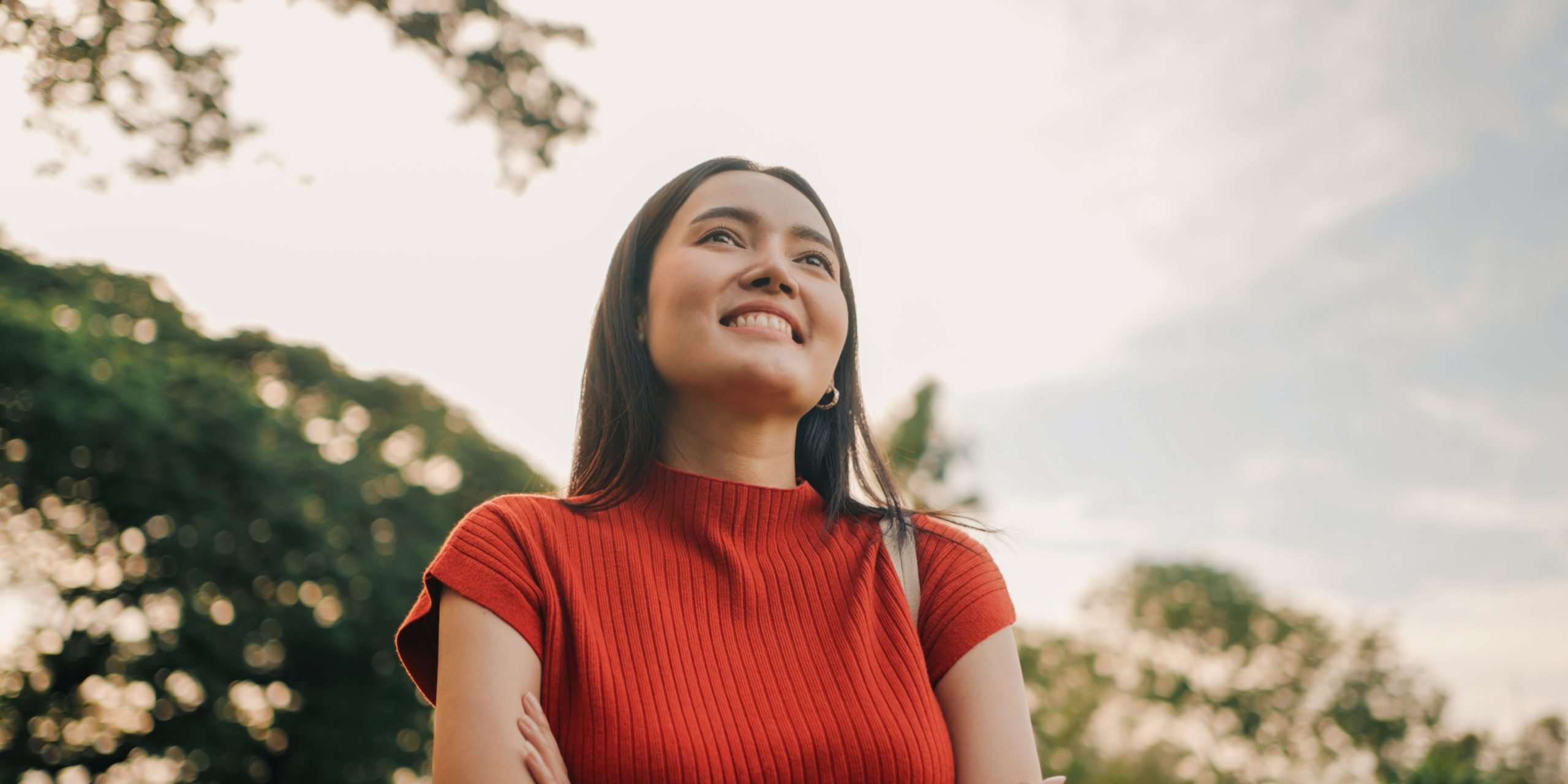 Smiling woman enjoying nature and freedom in sunny park setting