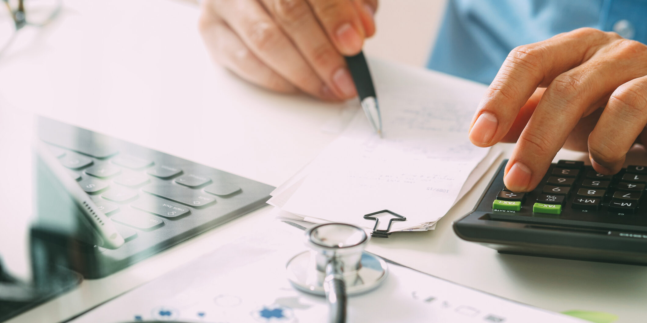 Healthcare costs and fees concept.Hand of smart doctor used a calculator for medical costs in modern hospital